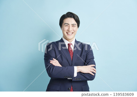 一位商人雙手交叉在胸前，臉上帶著微笑。 139583609