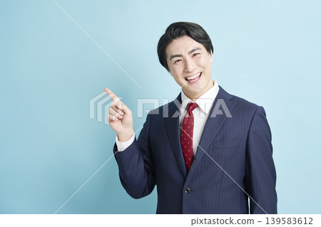 一位面帶微笑的商人指向左邊。 139583612
