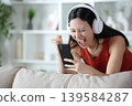Excited asian woman celebrating watching media on phone 139584287
