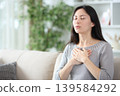 Asian woman exhaling doing breathing exercise 139584292