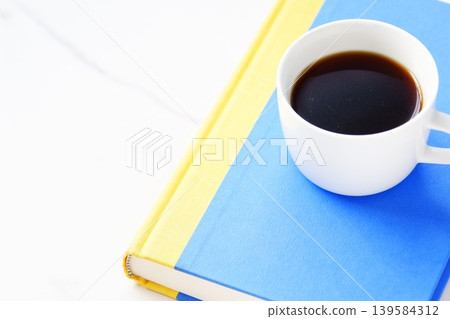 Reading - An image of leisurely enjoying a book while sipping a fragrant, freshly brewed cup of coffee. Reading - An image of leisurely enjoying a book while sipping a fragrant, freshly brewed cup of coffee. 139584312