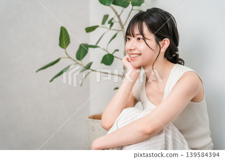 A profile view of a beautiful Asian woman with a lovely smile sitting on a wooden floor (Beauty, Diet, Hair Removal) A profile view of a beautiful Asian woman with a lovely smile sitting on a wooden floor (Beauty, Diet, Hair Removal) 139584394