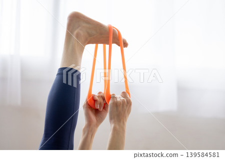 一位身穿瑜珈服的中年日本女性正在使用阻力帶進行鍛鍊。 139584581