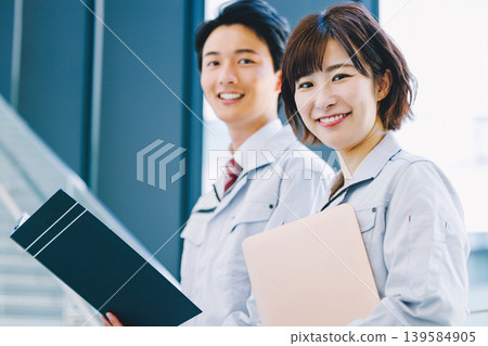 A smiling man and woman in work clothes A smiling man and woman in work clothes 139584905