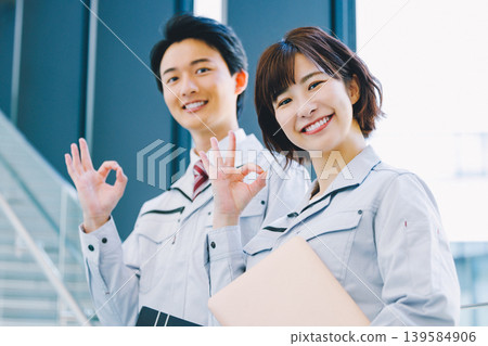 A smiling man and woman in work clothes 139584906