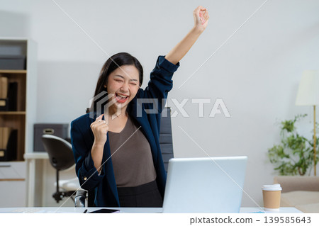 Overjoyed charming excited asian business woman worker using laptop and tablet working in office, feeling happy. Overjoyed charming excited asian business woman worker using laptop and tablet working in office, feeling happy. 139585643