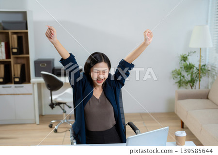 Overjoyed charming excited asian business woman worker using laptop and tablet working in office, feeling happy. Overjoyed charming excited asian business woman worker using laptop and tablet working in office, feeling happy. 139585644