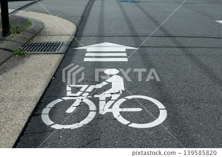 瀝青路面上繪製的自行車標誌。這張圖片旨在宣傳道路交通法修訂後的安全騎行。 139585820
