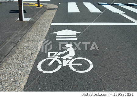 瀝青路面上繪製的自行車標誌。這張圖片旨在宣傳道路交通法修訂後的安全騎行。 139585821