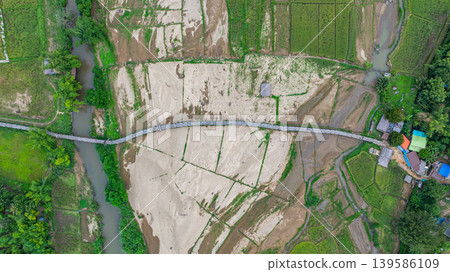 Aerial view of Su Tong Pae bamboo bridge connecting temple to village 139586109