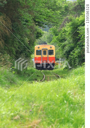 A Kiha train running through a mountainous area on the Kominato Railway. A Kiha train running through a mountainous area on the Kominato Railway. 139586328