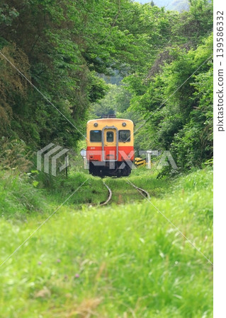 A Kiha train running through a mountainous area on the Kominato Railway. A Kiha train running through a mountainous area on the Kominato Railway. 139586332