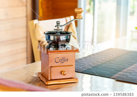 Vintage Manual Coffee Grinder on Wooden Table in Bright Cafe Vintage Manual Coffee Grinder on Wooden Table in Bright Cafe 139586383