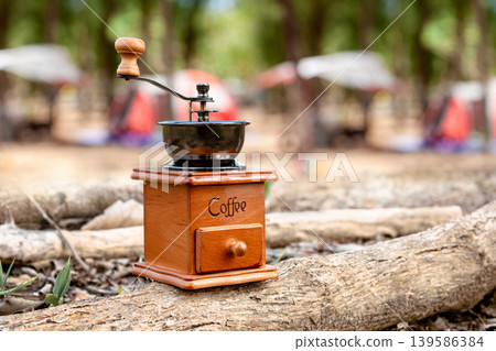 Vintage Coffee Grinder on Wood Log at Camping Site Vintage Coffee Grinder on Wood Log at Camping Site 139586384