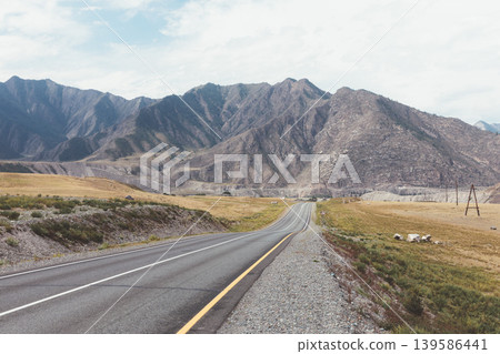 Scenic Chuysky Trakt highway through Altai Mountains valley under cloudy sky Scenic Chuysky Trakt highway through Altai Mountains valley under cloudy sky 139586441