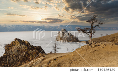 Shaman Rock on frozen Lake Baikal at sunset, Olkhon Island winter landscape Shaman Rock on frozen Lake Baikal at sunset, Olkhon Island winter landscape 139586489