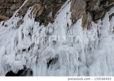 Frozen icicles and ice formations on rocky shore at Lake Baikal in winter Frozen icicles and ice formations on rocky shore at Lake Baikal in winter 139586493