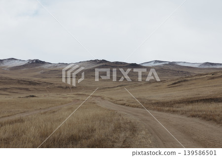 Empty dirt road through steppe hills on Olkhon Island, Lake Baikal, Russia 139586501