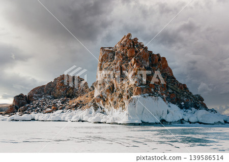 Shaman Rock on frozen Lake Baikal near Khuzhir under dramatic winter sky Shaman Rock on frozen Lake Baikal near Khuzhir under dramatic winter sky 139586514