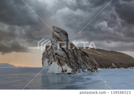 Dramatic winter landscape of Ogoy Island rock on frozen Lake Baikal at dusk Dramatic winter landscape of Ogoy Island rock on frozen Lake Baikal at dusk 139586523