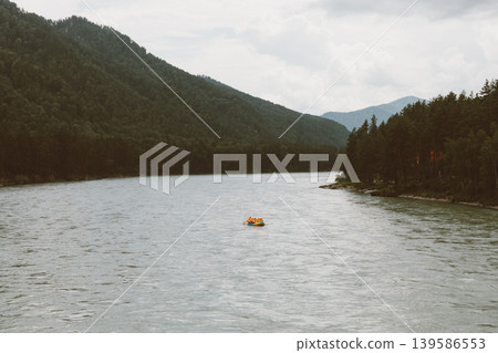 Rafting on mountain river in Altai, small boat on water between forest hills Rafting on mountain river in Altai, small boat on water between forest hills 139586553