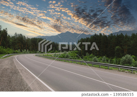Scenic mountain road in Altai with forest and dramatic sunset sky panorama Scenic mountain road in Altai with forest and dramatic sunset sky panorama 139586555