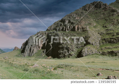 Rocky mountain cliff and green valley landscape in the Altai Mountains at dusk Rocky mountain cliff and green valley landscape in the Altai Mountains at dusk 139586595