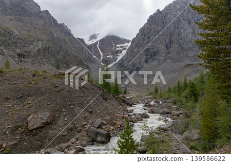 Mountain river in Aktru Valley with rocky peaks and clouds, Altai Republic Mountain river in Aktru Valley with rocky peaks and clouds, Altai Republic 139586622