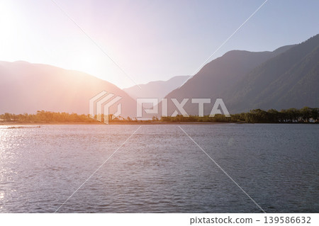 Sunset landscape on Lake Teletskoye with mountain silhouettes in Altai region Sunset landscape on Lake Teletskoye with mountain silhouettes in Altai region 139586632