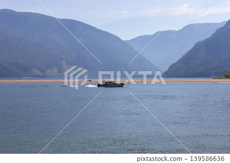 Motorboat cruising on Lake Teletskoye with mountain landscape in Altai Motorboat cruising on Lake Teletskoye with mountain landscape in Altai 139586636