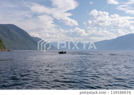 Scenic view of Teletskoye Lake with boat and mountains under cloudy sky 139586639