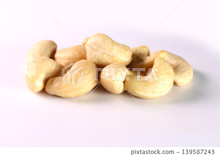 Close-up of a cashew nut placed against a white background. Close-up of a cashew nut placed against a white background. 139587243