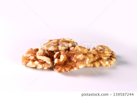 Close-up of shelled walnuts placed against a white background. Close-up of shelled walnuts placed against a white background. 139587244