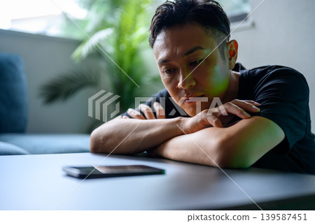 Japanese man staring at his smartphone 139587451