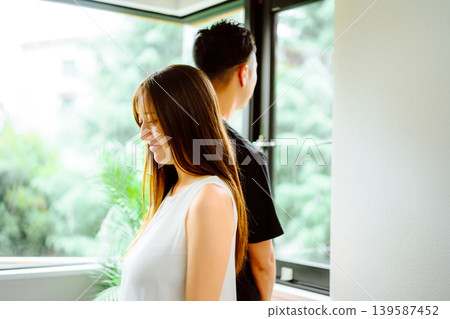 A couple standing by the window 139587452