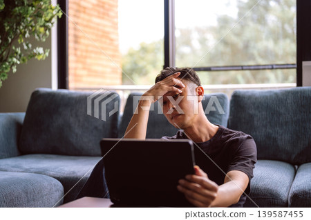 A man pondering in front of a sofa 139587455