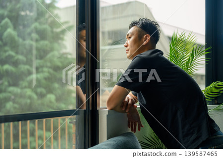 A man looking out the window A man looking out the window 139587465