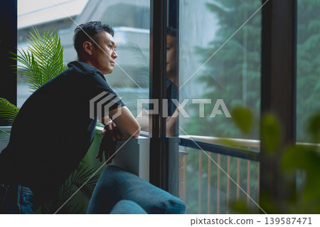 一個男人正望著窗外。 139587471