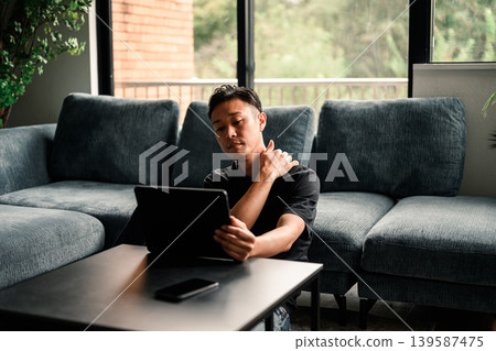 一個人在客廳裡看到一台平板電腦 139587475