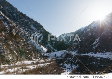 Winter sunburst over Kegety Gorge mountain valley with snow and pine forest Winter sunburst over Kegety Gorge mountain valley with snow and pine forest 139587528