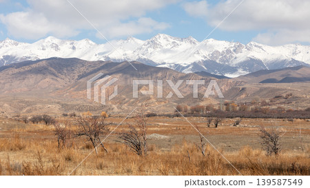Snow-capped Tian Shan mountains and dry valley landscape in Kyrgyzstan, Central Asia Snow-capped Tian Shan mountains and dry valley landscape in Kyrgyzstan, Central Asia 139587549