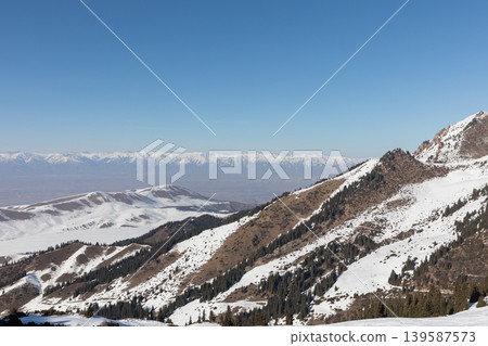 Snowy mountain ridges and ski slopes near Karakol ski resort, Kyrgyzstan 139587573