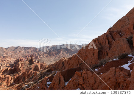 Scenic red sandstone formations in Skazka Canyon near Issyk-Kul Lake at sunrise Scenic red sandstone formations in Skazka Canyon near Issyk-Kul Lake at sunrise 139587575