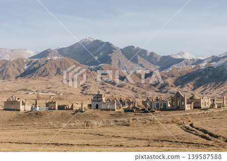 Rural cemetery with mausoleums in Kyrgyzstan mountains under winter sky 139587588
