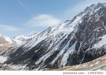 Snowy mountain landscape in Barskoon Gorge with rocky peaks and blue sky Snowy mountain landscape in Barskoon Gorge with rocky peaks and blue sky 139587602