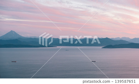 Avacha Bay seascape at pink sunset with volcano silhouette, Kamchatka coast Avacha Bay seascape at pink sunset with volcano silhouette, Kamchatka coast 139587651
