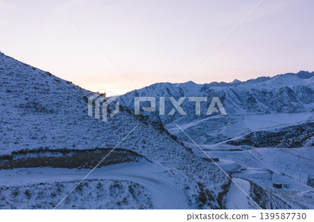 Chunkurchak Valley winter mountain landscape with snowy road at sunrise, Kyrgyzstan Chunkurchak Valley winter mountain landscape with snowy road at sunrise, Kyrgyzstan 139587730