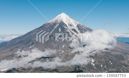 Koryaksky volcano peak above clouds, dramatic mountain landscape in Kamchatka Koryaksky volcano peak above clouds, dramatic mountain landscape in Kamchatka 139587753