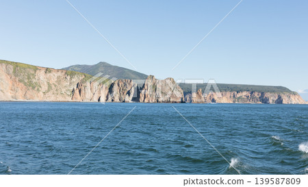 Rocky sea cliffs and volcanic coastline landscape in Kamchatka at sunny day Rocky sea cliffs and volcanic coastline landscape in Kamchatka at sunny day 139587809