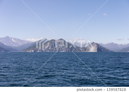 Coastal mountains and rocky cliffs across the Pacific Ocean in Kamchatka Coastal mountains and rocky cliffs across the Pacific Ocean in Kamchatka 139587828